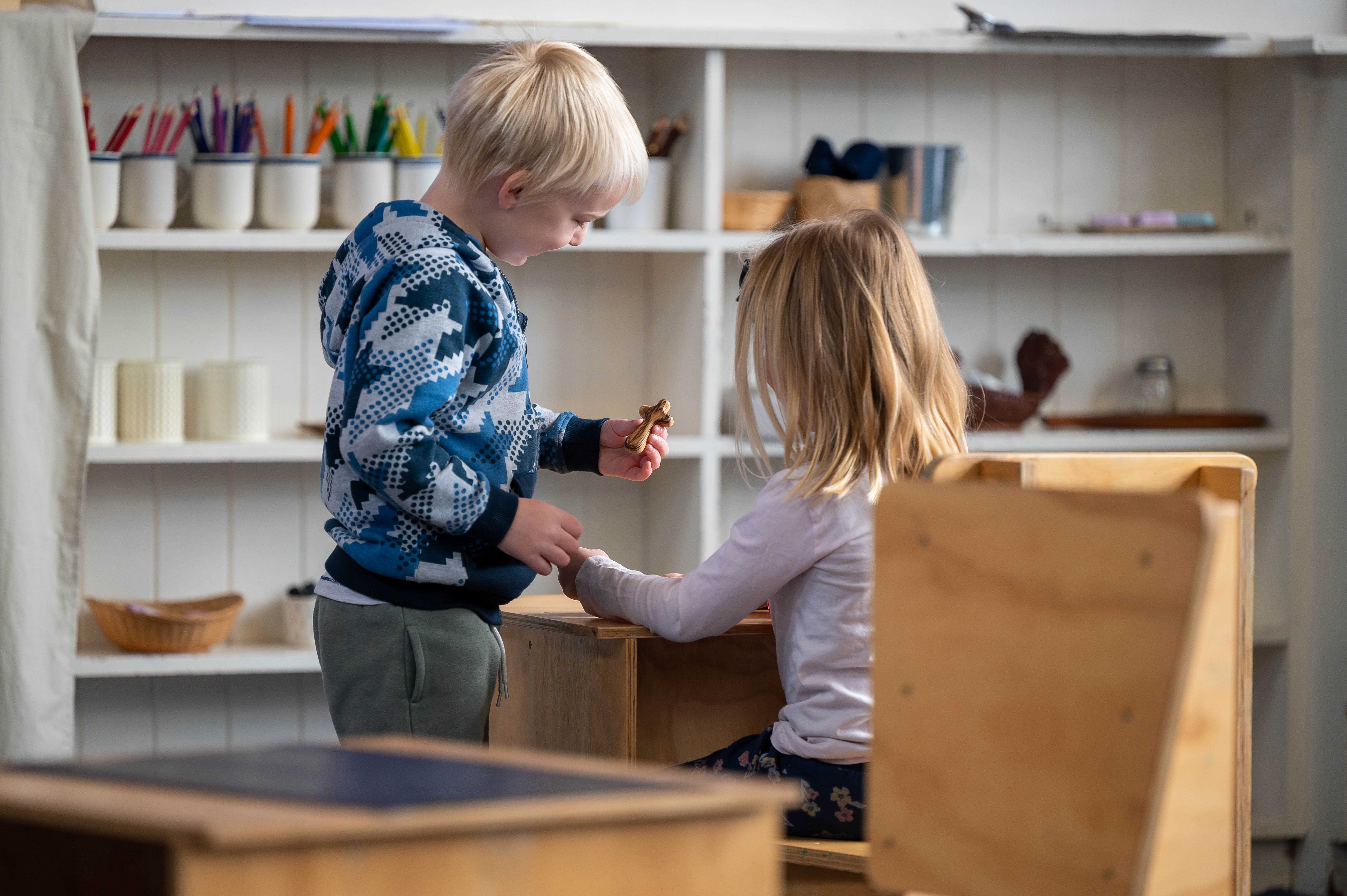 Children delighting in a wooden cross