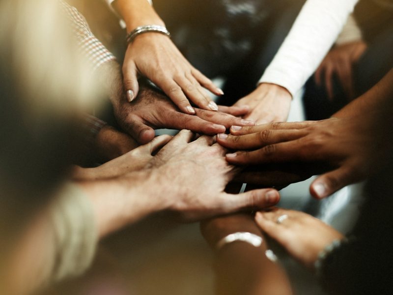 Closeup diverse people joining their hands