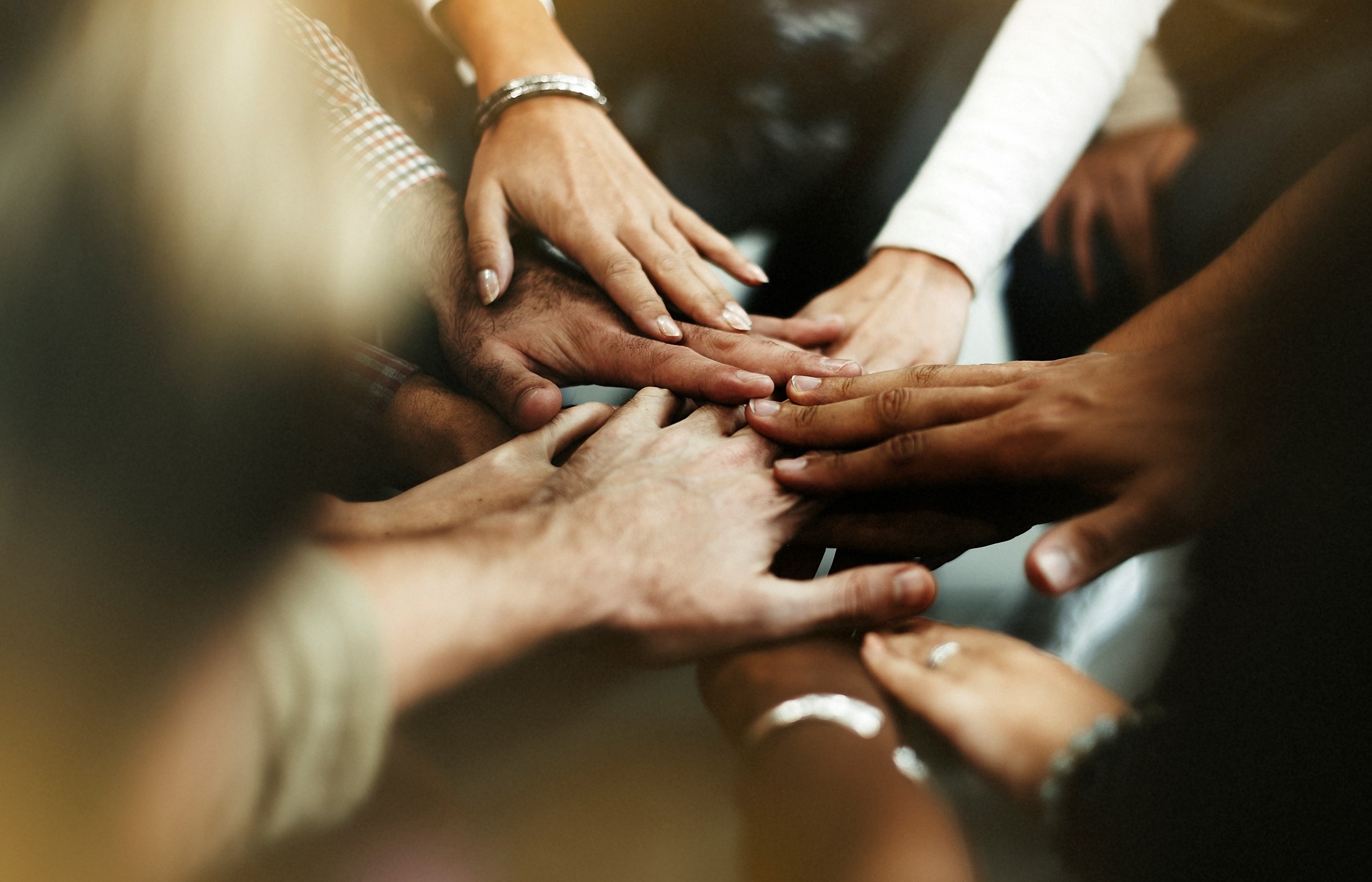 Closeup diverse people joining their hands